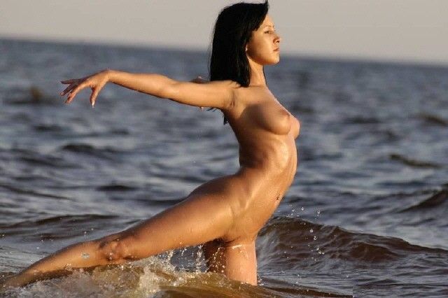 Обнаженная балерина танцует на пляже