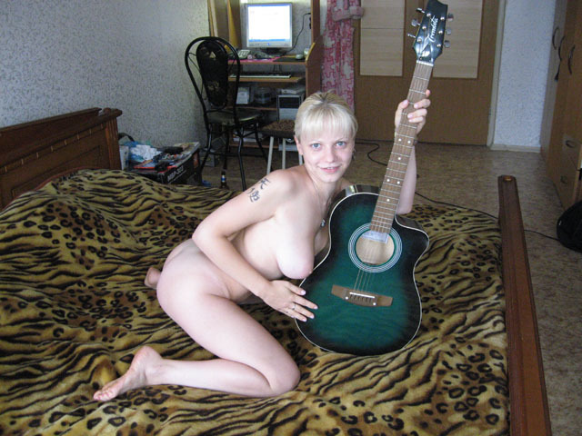 Блонда с огромным бюстом трогает гитару